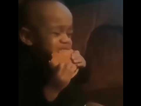 The image features a baby enthusiastically biting into a food item, showcasing sheer delight and eagerness. The baby's demeanor is one of pure joy, with a focused expression as they savor the taste, embodying an infectious enthusiasm that resonates with anyone who has experienced the simple pleasure of a delicious meal.

The background appears to be a soft, muted tone, likely indicating a cozy indoor setting, which adds to the warm, intimate feel of the moment. This context enhances the overall sentiment of comfort and happiness associated with good food.

This scene captures the essence of the "Hungry Baby" meme, a symbol of excitement related to food, humorously expressing how we all feel when faced with something delicious. The baby seems almost in a trance, highlighting the amusing relationship humans have with food—it's not just nourishment; it's a source of joy!