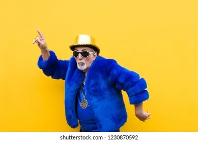 In this vibrant image, an elderly man exudes a lively demeanor, dressed in a striking blue fur coat that contrasts brilliantly against a sunny yellow background. He sports a shiny gold top hat and oversized sunglasses, suggesting a playful, carefree attitude. The gold chain around his neck adds an element of bling, enhancing his flamboyant style.

His pose, with one arm raised and a finger pointing, conveys a sense of celebration or perhaps an invitation to join in on the fun, reminiscent of a dance party vibe. The bright colors and his exuberant outfit evoke a whimsical, almost meme-worthy quality, potentially linking to cultural themes of self-expression and joy.

The yellow backdrop amplifies the image's cheerful atmosphere, making it feel like a snapshot from a lively event or a humorous social media moment. Overall, this image captures the essence of fun and individuality.