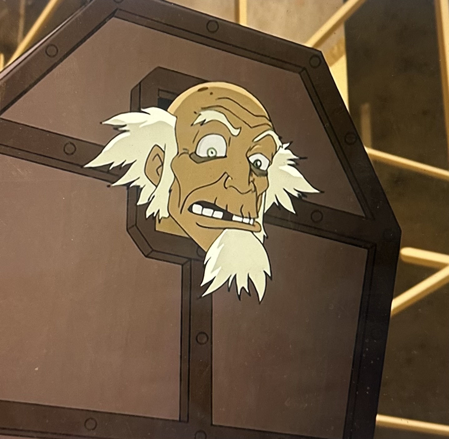 The image features Uncle Iroh, a beloved character from "Avatar: The Last Airbender." He is depicted peering out from a wooden crate, his expression a mix of concern and surprise. His iconic white hair and beard add to his distinct character design, embodying both wisdom and humor.
In the background, you can see hints of a more industrial setting, suggesting a scene where Iroh might be caught in an unexpected situation, perhaps even related to the comedic escapades typical of the series. The juxtaposition of his wise demeanor with the absurdity of being in a crate adds a humorous element, highlighting Iroh's ability to find himself in quirky predicaments while maintaining his charm. Overall, the scene captures the essence of friendship and growth, central themes throughout the series.