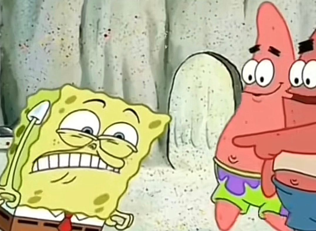 This humorous still from the animated series *SpongeBob SquarePants* captures Spongebob Squarepants on the left, his yellow, porous body contorted with a strained, gritted-teeth expression, eyes squinted in intense effort. He holds a small white shovel, embodying the widely recognized 'Spongebob straining meme.' In stark contrast, Patrick Star stands on the right, wearing a wide, cheerful smile and pointing forward with a relaxed demeanor, a gesture often associated with the 'Patrick pointing meme.' Another pink starfish is partially visible behind Patrick, also smiling. The background is a light, sandy, textured underwater landscape, typical of Bikini Bottom, featuring a large, light-colored rock formation, perfectly setting the scene for their aquatic antics.