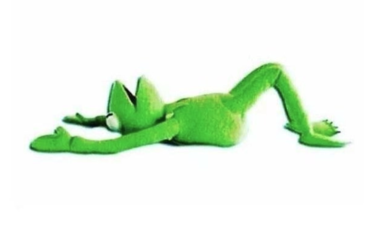 The image shows a green frog-like character lying on its back with its arms stretched out forward and legs bent at the knees. The character appears to be a plush toy or a digital rendering with a smooth texture. The background is plain white, making the character the sole focus of the image.