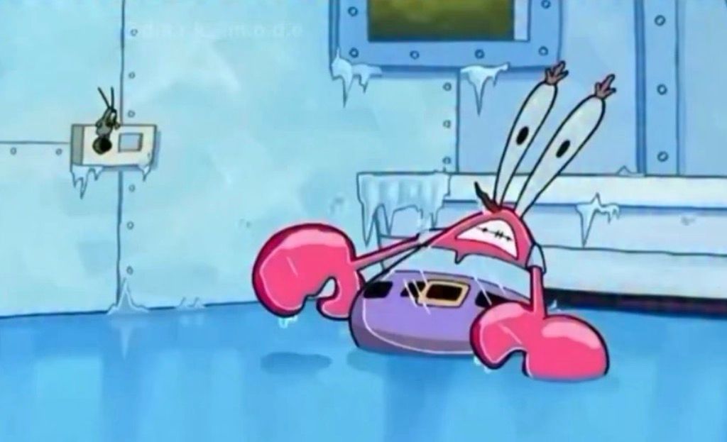 This humorous still from SpongeBob SquarePants captures Mr. Krabs frozen solid in a state of comical panic. His large, white eyestalks are wide with alarm, and his gritted teeth reveal a look of utter shock and discomfort. Encased in a block of ice, his pink claws are comically outstretched, as if he was caught mid-gesture. The background is a frigid, light blue underwater scene, with jagged icicles clinging to the walls and a thin layer of ice covering the floor, perfectly setting the scene for his chilly predicament. A small, dark creature, possibly Plankton, is also frozen to the wall in the upper left, adding to the frozen chaos.