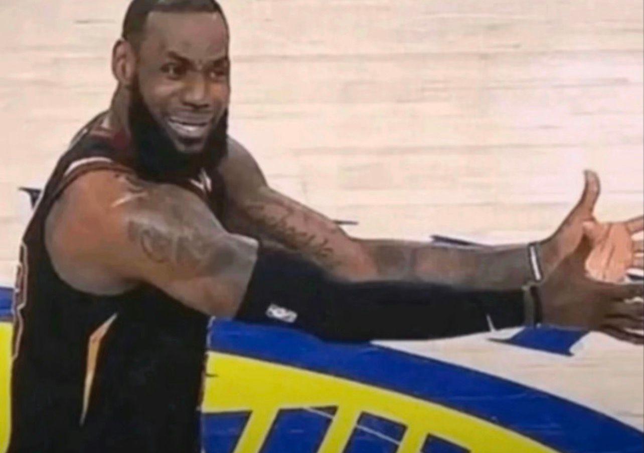 In this iconic image, LeBron James is captured mid-game displaying a humorous and incredulous expression. His face is contorted in disbelief, with raised eyebrows and a slight grin, as he gestures with outstretched arms, seemingly questioning a call or play. The context is significant; this moment has resonated with fans, becoming a widely shared meme that encapsulates the frustrations and absurdities often experienced in sports.

The background features the court of an NBA game, with vibrant team colors and markings that reinforce the competitive atmosphere. This setting adds depth to his reaction, as it highlights the high stakes of the situation. The image perfectly combines athleticism and humor, making it relatable for anyone who has ever felt bewildered by a decision, be it in sports or everyday life.