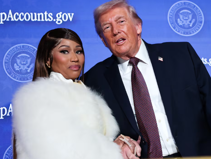 In this image, Donald Trump and Nicki Minaj stand side by side, both displaying confident demeanors. Trump wears a suit, showing his typical political persona, while Minaj is adorned in a stylish white fur coat, reflecting her vibrant celebrity flair. Their poses suggest a moment of camaraderie, possibly at a public event aimed at addressing social issues, as indicated by the backdrop featuring a government website.

The blue backdrop, accented with the presidential seal, reinforces the political context, mixing the worlds of politics and pop culture. The juxtaposition of Trump's serious expression and Minaj's playful yet poised demeanor evokes a humorous contrast, as if they are two unlikely allies at a debate of style versus substance. The scene captures a unique moment where entertainment meets politics, hinting at discussions that might be as colorful as their attire.