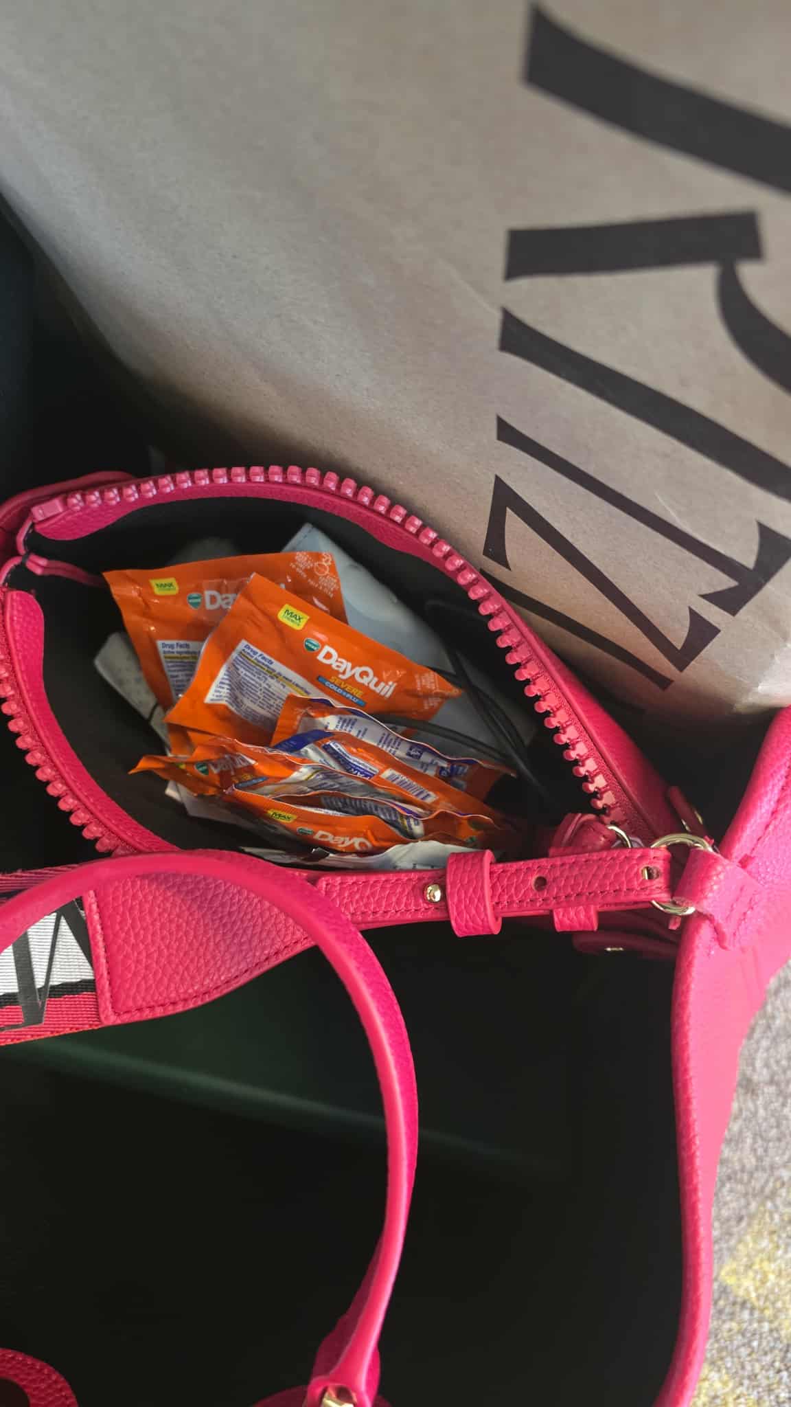 Pink bag flexing DayQuil like it’s curing world hunger.