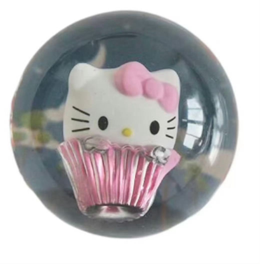 This image showcases a delightful Hello Kitty figurine, a globally recognized character from Sanrio, presented as a charming cupcake. Her iconic white head, featuring black dot eyes, a yellow nose, and three whiskers on each side, is adorned with a cheerful pink bow on her left ear. Her demeanor is characteristically serene and sweet, embodying the kawaii aesthetic. She emerges from a vibrant pink, fluted cupcake wrapper, suggesting she's either a delicious treat or a decorative item. The entire Hello Kitty cupcake is encased within a clear, spherical orb, likely a snow globe, with a dark, reflective background. The humor lies in her calm, unchanging expression despite being a delectable, contained dessert, ready to brighten anyone's day.
