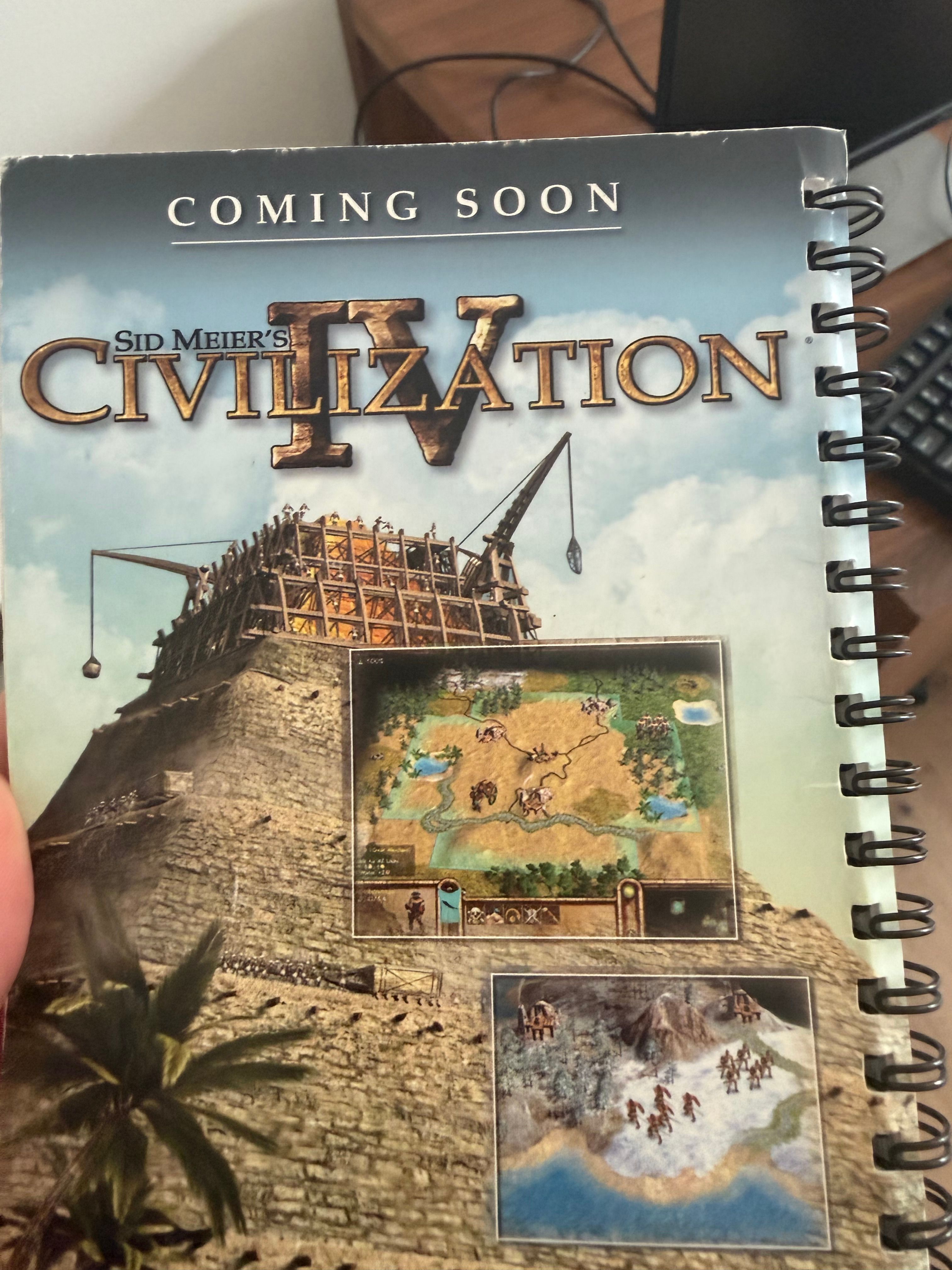 The image showcases a promotional cover for "Sid Meier's Civilization IV," featuring a striking illustration of a large, intricately designed structure resembling a ziggurat or pyramid, towering against a blue sky. The structure is equipped with a crane, suggesting construction or development, which aligns with the game's theme of civilization building. The cover includes gameplay screenshots, displaying maps with rivers and landscapes, hinting at strategic gameplay elements. The subject's demeanor is one of anticipation and excitement, as the text "COMING SOON" builds excitement for the game's release. In the background, the computer setup adds a casual, relatable context, suggesting this is a gamer’s workspace, ready for the adventures that lie ahead in the game. The overall vibe is playful, inviting players to immerse themselves in a world of strategy and expansion, ripe for exploration. Humorously, one might think the construction workers are just trying to build a better civilization, one pyramid at a time!