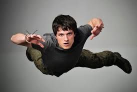 Josh Hutcherson is captured mid-air against a stark grey background, giving the impression of flight or a dramatic fall. His demeanor is a mix of surprise and intense focus, with wide eyes and a slightly open mouth, as if exclaiming or bracing for impact. His arms are outstretched, hands open, adding to the dynamic, action-packed pose. This image strongly aligns with promotional material for his action-oriented roles, such as those in 'The Hunger Games' or 'Journey to the Center of the Earth', where he often portrays characters in perilous, high-stakes situations. The plain background isolates him, emphasizing his suspended state and the urgency of the moment, almost as if he's just realized he forgot his parachute. It's a classic hero shot, ready for adventure.