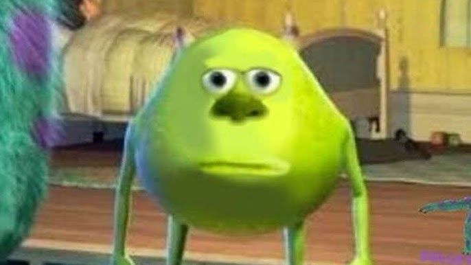 The image features an animated green character with a round, spherical body and two small horns on top of its head. The character has large, wide eyes and a small, flat nose. Its mouth is closed, giving it a neutral or slightly displeased expression. The character’s arms are thin and hang down by its sides, while its legs are short and also thin. The body posture is upright, and the character appears to be standing still.
In the background, there is a bed with a headboard and some bedding, suggesting an indoor setting, possibly a bedroom. The floor appears to be wooden, and there is a rug visible.
Overall, the scene has a slightly awkward or surreal vibe due to the character's exaggerated features and expression, which do not convey any clear emotion. The image suggests a still moment with no apparent action occurring.