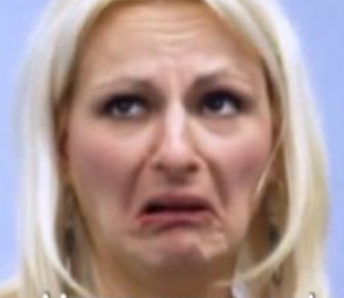 The subject is a woman with blonde hair, presenting a pronounced expression of disgust or discomfort. Her eyebrows are furrowed, eyes slightly squinted, and mouth turned down in a grimace, conveying a strong negative reaction. The close-up framing focuses entirely on her face, with a blurred, neutral blue background that offers no contextual clues, emphasizing her emotional state. The lack of environment or setting heightens the intensity of her expression, making it the sole focus. The tension lies in the stark contrast between her visible distress and the absence of any visible cause, which can feel awkward or humorous, as if reacting dramatically to an unseen or trivial stimulus. This isolated emotional display could easily be interpreted as a meme-worthy moment due to its exaggerated, almost theatrical nature.