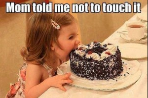 The image humorously captures a young child, likely around three or four years old, poised to devour a chocolate cake. Her wide, innocent eyes gleam with mischief, and her expression radiates sheer delight and defiance, as if she’s about to break a major rule. The cake, decorated with cream and sprinkles, sits enticingly on a plate in front of her, further emphasizing the temptation. The context of the caption, "Mom told me not to touch it," adds a layer of humor, showcasing the classic childhood scenario of defiance against parental warnings.
The background appears softly blurred, possibly suggesting a domestic setting like a party or family gathering, enhancing the intimate feel of the moment. This scene embodies the universal struggle of children against temptation, making it relatable and funny. It's a perfect illustration of innocent mischief, encapsulated in a single snapshot.