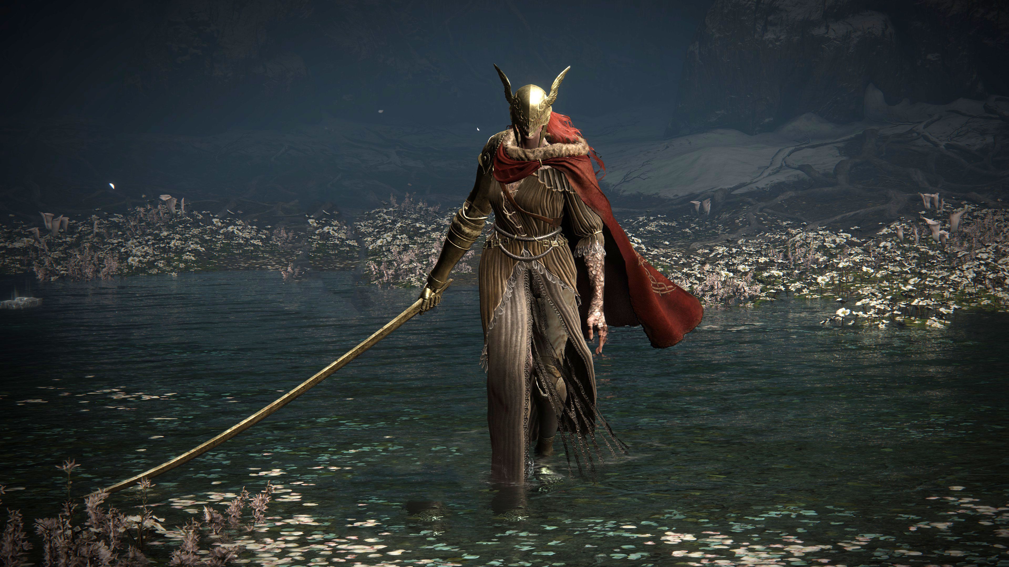The image depicts a striking character emerging from a serene body of water, adorned in elaborate, tattered robes and a majestic, gold-plated helmet with wings, suggesting a regal or heroic demeanor. The character's outstretched arm clutches a long staff, emphasizing an air of authority and determination. The flowing red cape adds a dramatic flair, contrasting beautifully against the muted colors of the surroundings.  

In the background, the still water reflects patches of flowers, enhancing the tranquil yet mysterious atmosphere. Shadows loom from the darkened rocks, hinting at an unseen depth, perhaps a metaphor for the challenges faced by the character. This scene evokes a feeling reminiscent of epic fantasy narratives, possibly from a video game like "Elden Ring," where themes of valor and exploration intertwine. The character seems to stride purposefully, embodying both grace and power, as if ready to confront whatever lies ahead.