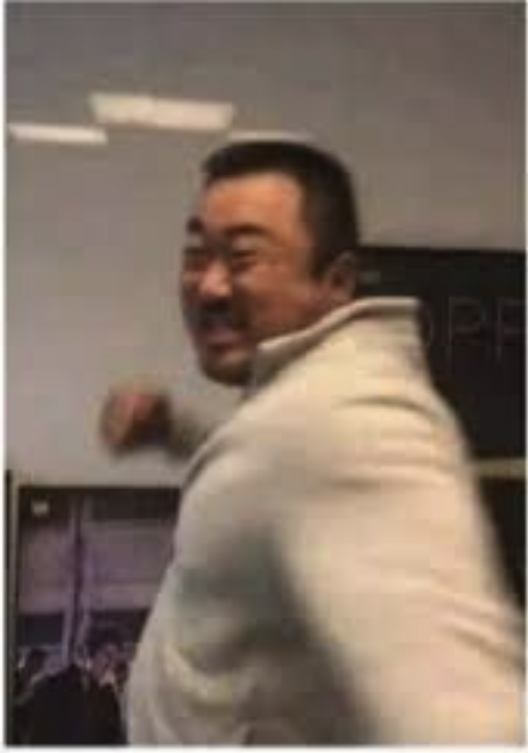 The image captures a man with a playful demeanor, sporting a wide grin as he turns slightly away from the camera. He wears a light-colored sweater, which emphasizes his joyful expression. The background appears to be an indoor setting with blurred outlines of what seems to be framed photographs or artwork, but specific details are unclear.

The subject's lively attitude suggests he is engaged in a light-hearted moment, perhaps mid-laugh or during a fun interaction. The blurred background adds to the focus on his energetic presence, creating a sense of spontaneity.

While this image could be reminiscent of a meme or humorous moment, it's not directly tied to a specific cultural event or show. The overall vibe is one of joy and humor, inviting viewers to share in the laughter without any overt context.