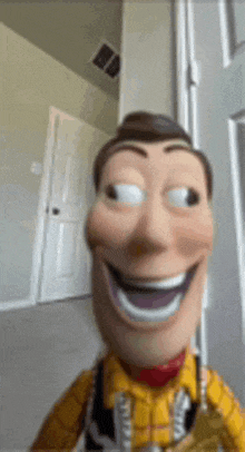 This image features a close-up of Woody from Disney/Pixar's Toy Story, captured in a popular meme format. His plastic face is comically distorted with an exaggerated, wide-open smile revealing white teeth, and his eyes are dramatically rolled to the upper right, giving a mischievous or slightly unhinged side-eye. He wears his iconic yellow plaid shirt and sheriff's badge. The background is a simple, blurry indoor setting with light-colored walls, a white door, and a dark vent on the ceiling, providing a neutral backdrop that emphasizes Woody's unsettling yet humorous expression. His demeanor is one of exaggerated cheerfulness mixed with a hint of playful creepiness, making it a classic internet meme.