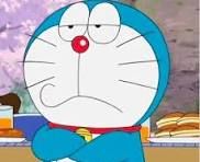 In this image, we see Doraemon, the iconic robotic cat from Japanese pop culture. His expression is one of mild irritation or contemplation, with his arms crossed and a slightly pouting mouth, which adds a humorous touch to the scene. Doraemon often embodies a mix of wisdom and playfulness in his adventures, and here he seems to be pondering a situation, possibly involving his friend Nobita's antics.
The background appears to be a casual picnic setting, with food items like sandwiches and drinks, indicating a lighthearted moment among friends. This context enhances the comedic elements—Doraemon's serious demeanor juxtaposed with the fun of the picnic scene, suggesting he may be dealing with some chaos caused by his companion. The overall vibe is relatable and amusing, capturing the essence of Doraemon's character as he navigates humorous challenges.
