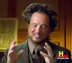 This iconic image features Giorgio A. Tsoukalos, widely known as "the Ancient Aliens guy," mid-sentence with an animated and slightly bewildered expression. His famously wild, gravity-defying hair is a prominent feature, adding to his unique persona. He's wearing a suit and tie, with both hands raised and open, as if explaining a complex, perhaps extraterrestrial, concept. The background is a softly blurred indoor setting, likely a study or library, typical for a documentary interview. The History Channel logo in the bottom right corner confirms its origin from the popular "Ancient Aliens" series. His demeanor is one of passionate conviction, making the image a humorous and instantly recognizable meme, often associated with the phrase "I'm not saying it was aliens... but it was aliens."