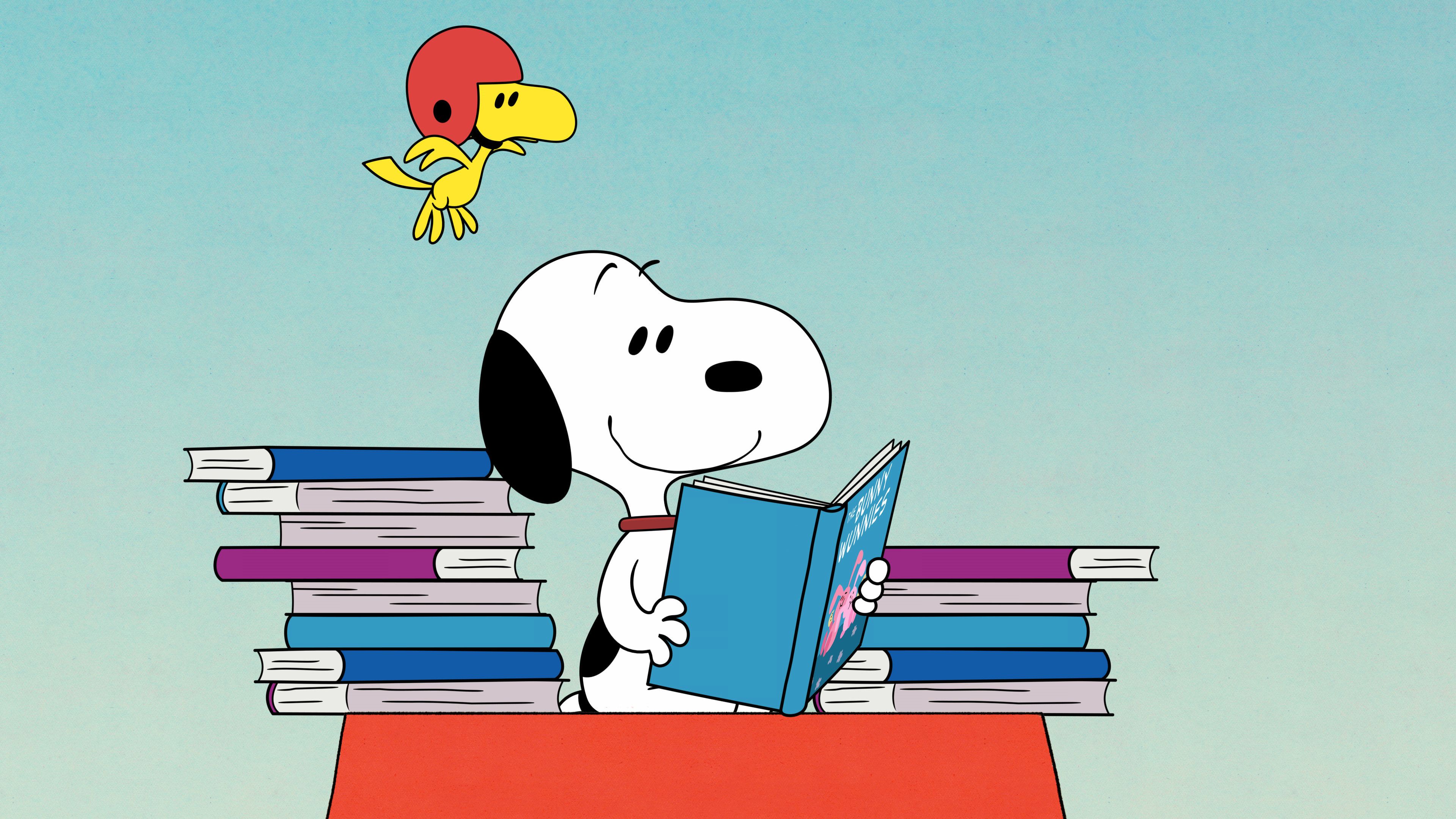 This charming image features the iconic Peanuts characters, Snoopy and Woodstock, engaged in a delightful reading session. Snoopy, the beloved beagle, sits contentedly on a vibrant red surface, surrounded by towering stacks of colorful books. He holds a blue book titled 'The Bunny Hunnies' (partially visible) with a serene, happy smile, completely engrossed in his literary adventure. Above him, his loyal companion Woodstock, sporting a bright red helmet, hovers mid-air with an inquisitive expression, perhaps wondering what exciting tales Snoopy is devouring. The simple, textured light blue background emphasizes the characters and their scholarly pursuit. The humor lies in Snoopy, a dog, being an avid reader, and Woodstock's quirky helmet, adding a touch of whimsical charm to this classic scene of friendship and learning from the Peanuts universe.