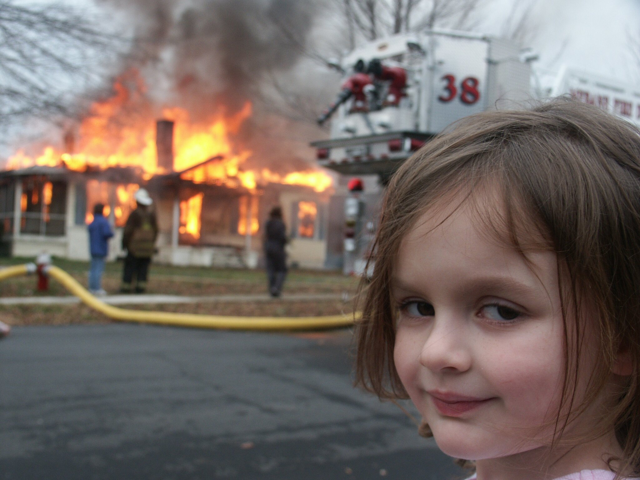The image depicts a young girl with a subtle smirk, seemingly unfazed by the chaos unfolding behind her. Her demeanor conveys a mix of curiosity and nonchalance, contrasting sharply with the intense scene of a house engulfed in flames. Smoke billows into the sky, while firefighters work diligently in the background, highlighting the urgency of the situation.
The background, with its flaming structure and emergency responders, serves as a stark reminder of the danger present, creating a tension that is almost surreal against the girl's calm expression. This juxtaposition brings a darkly humorous element to the scene, as her innocent demeanor contrasts with the alarming reality of a fire rescue.
The image captures a moment that feels almost meme-worthy, encapsulating the idea of "this is fine" in a chaotic world, where sometimes, unexpected humor can be found amidst distress.